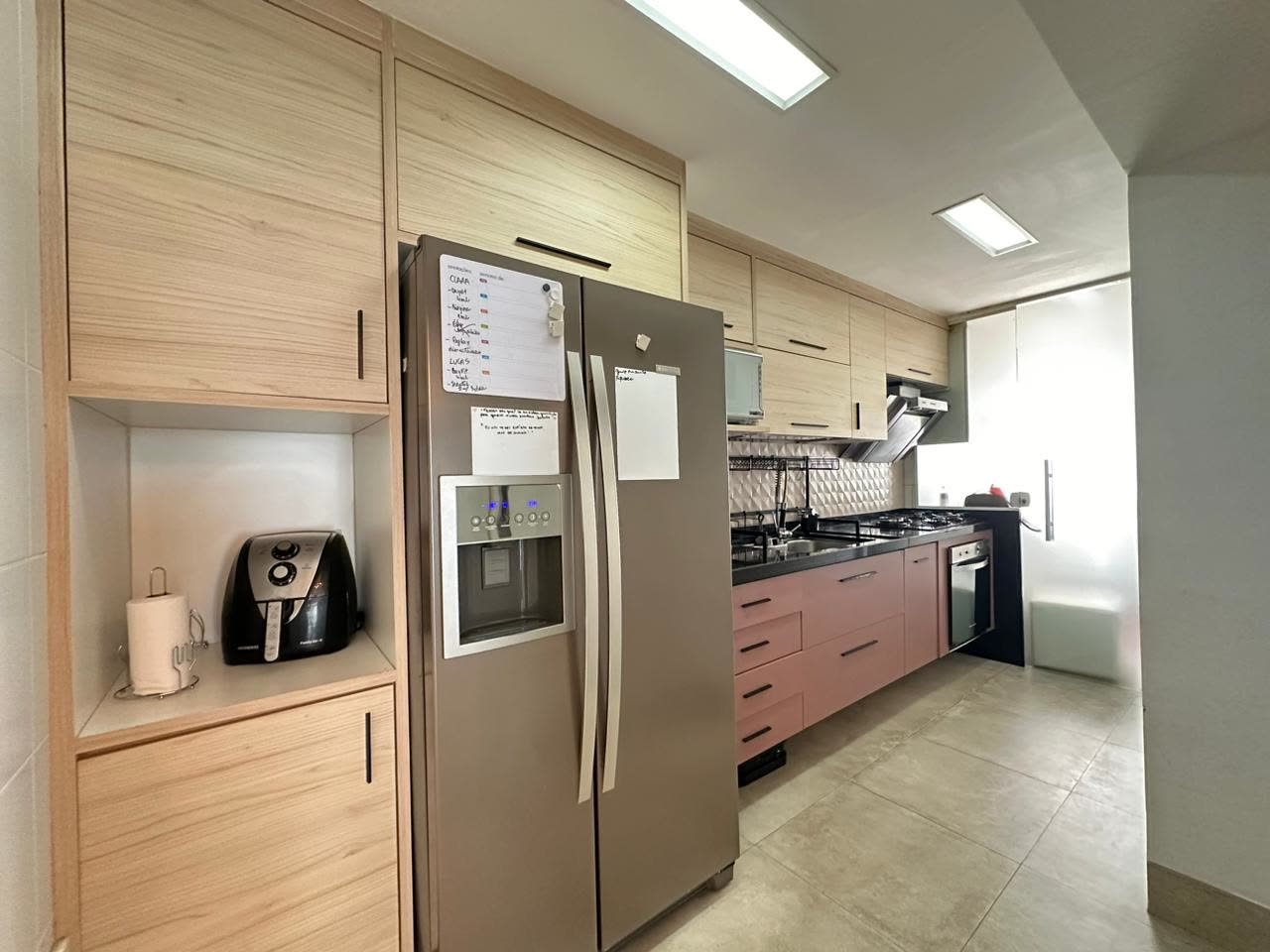 Cozinha planejada com armários amadeirados, cooktop e forno embutido