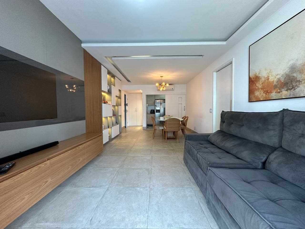 Sala de estar e jantar integrados com piso porcelanato de grande formato