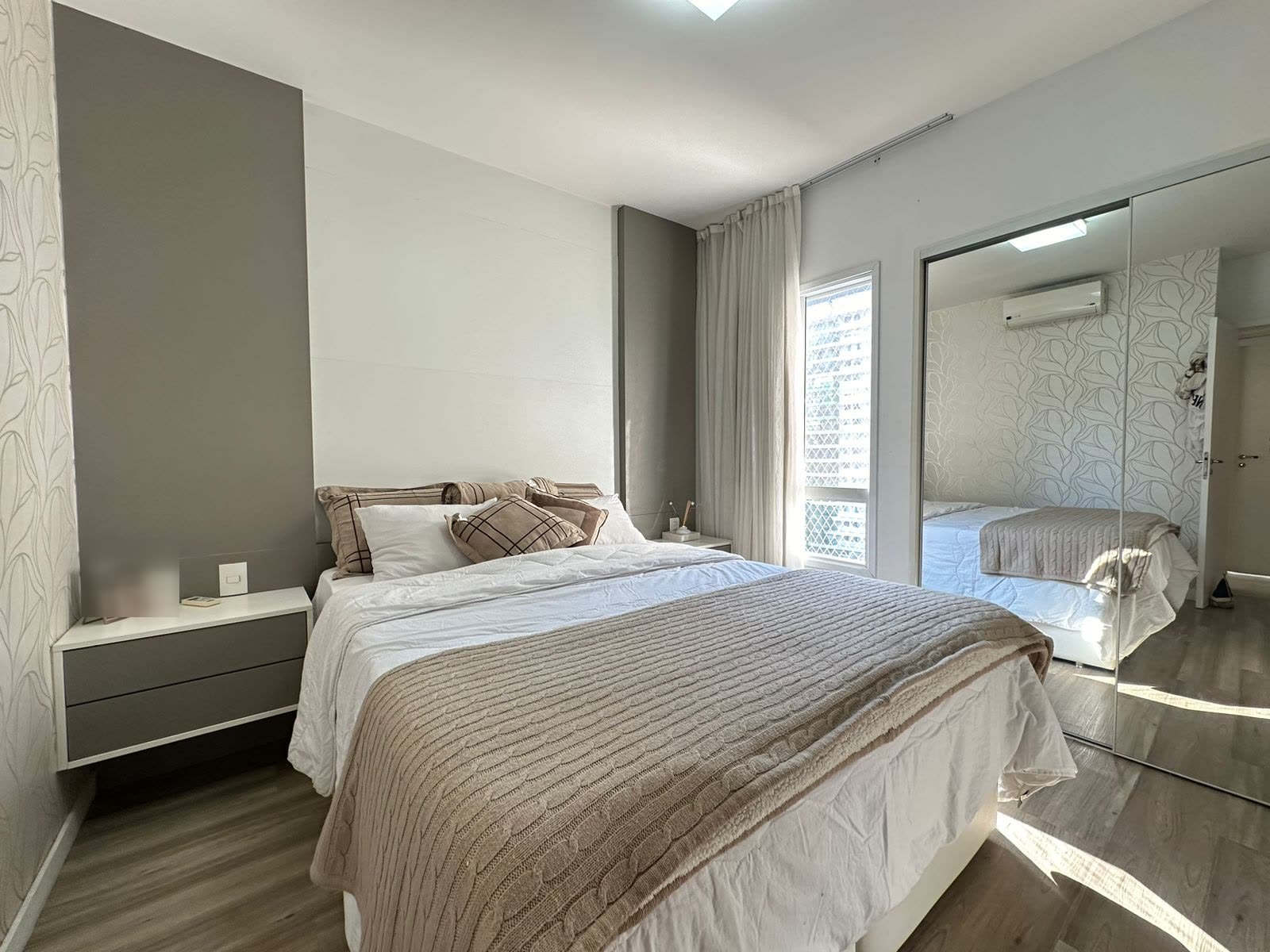 Suíte master com closet, papel de parede e armários espelhados