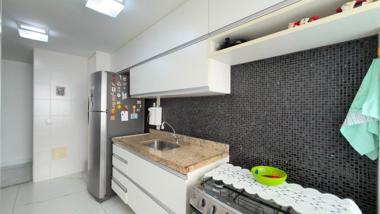 Cozinha com bancada em granito, cooktop e revestimento em pastilha