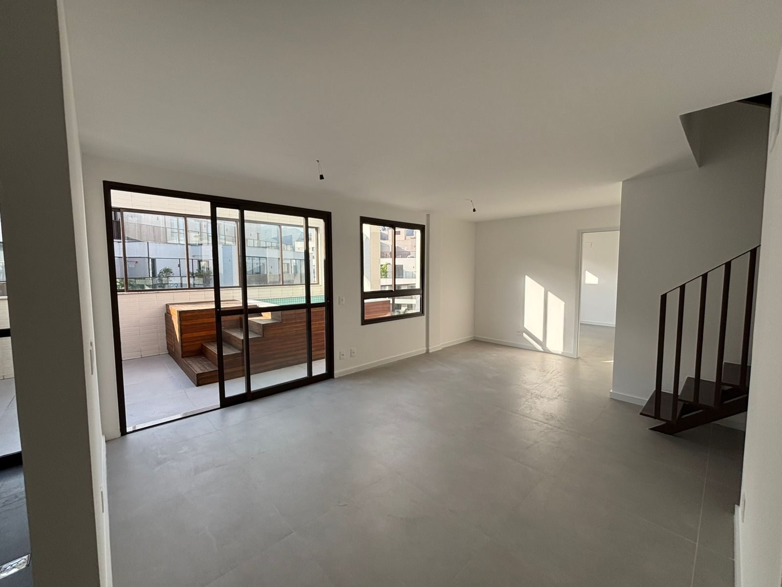 Sala da unidade 303 do All Jardim Oceânico, com escada interna para o segundo pavimento