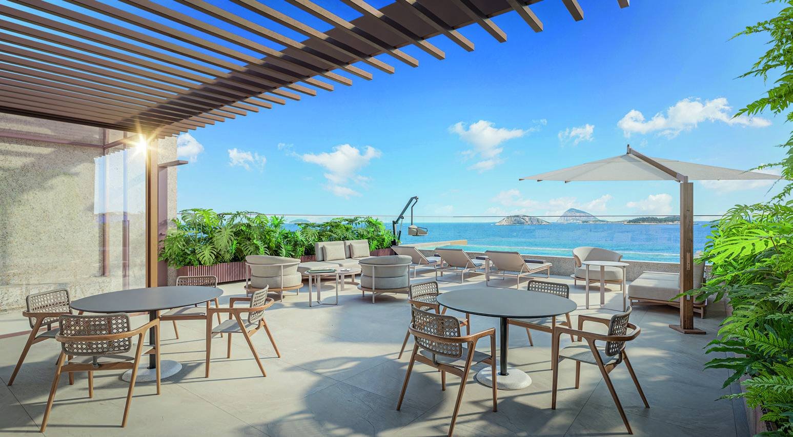 Espaço gourmet do rooftop do Bronze Ipanema Studios, com mesas sob pergolado e vista para o mar