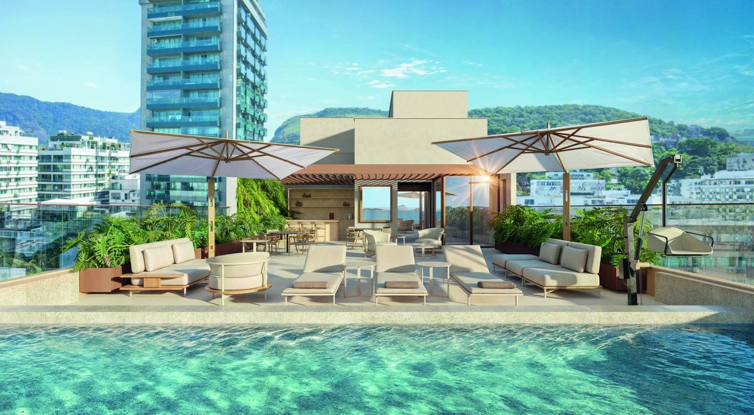 Solarium do rooftop do Bronze Ipanema Studios, com guarda-sóis, espreguiçadeiras e vista para a praia