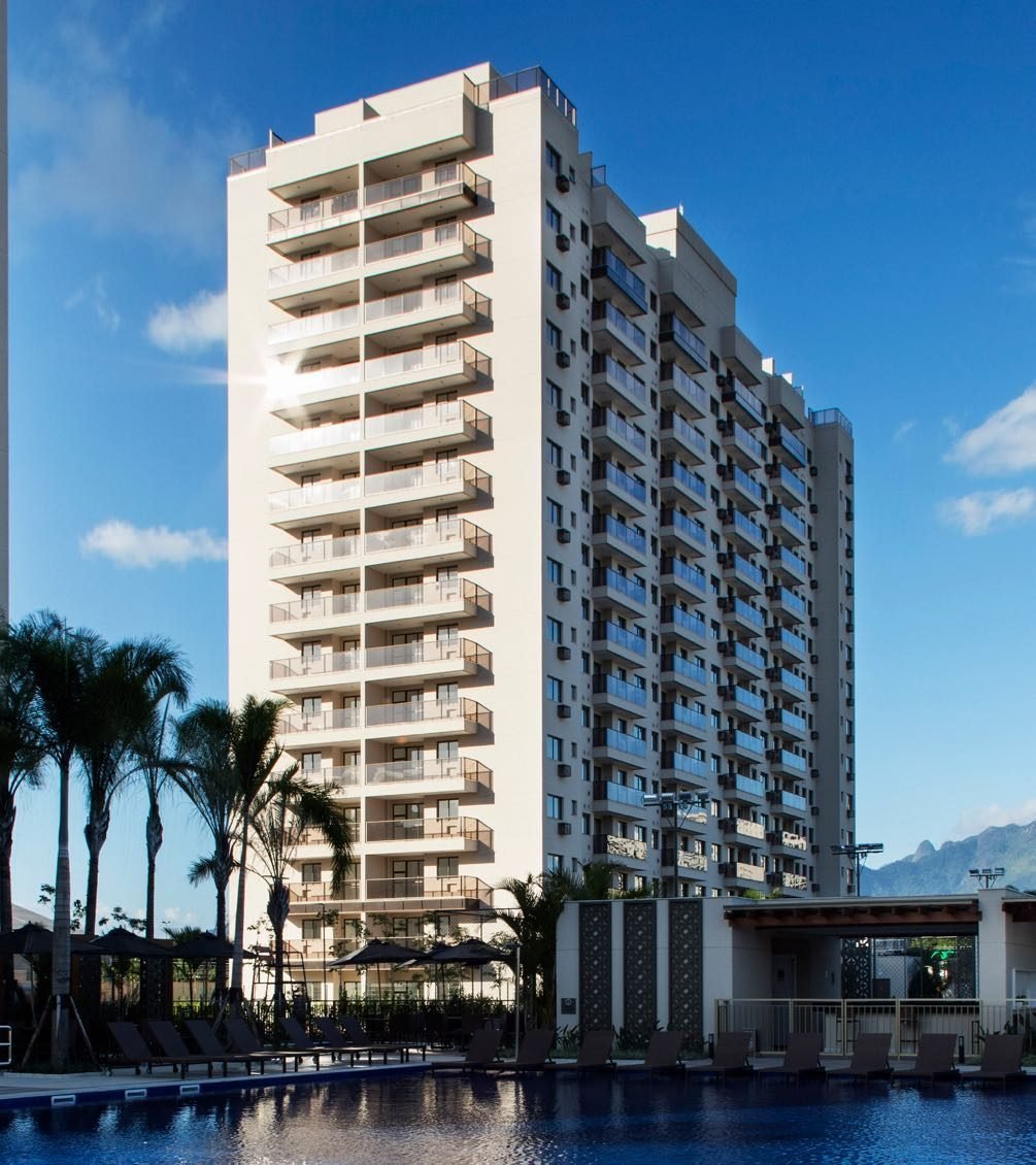 Fachada de um dos edifícios do Like Residencial Club vista de baixo, com palmeiras