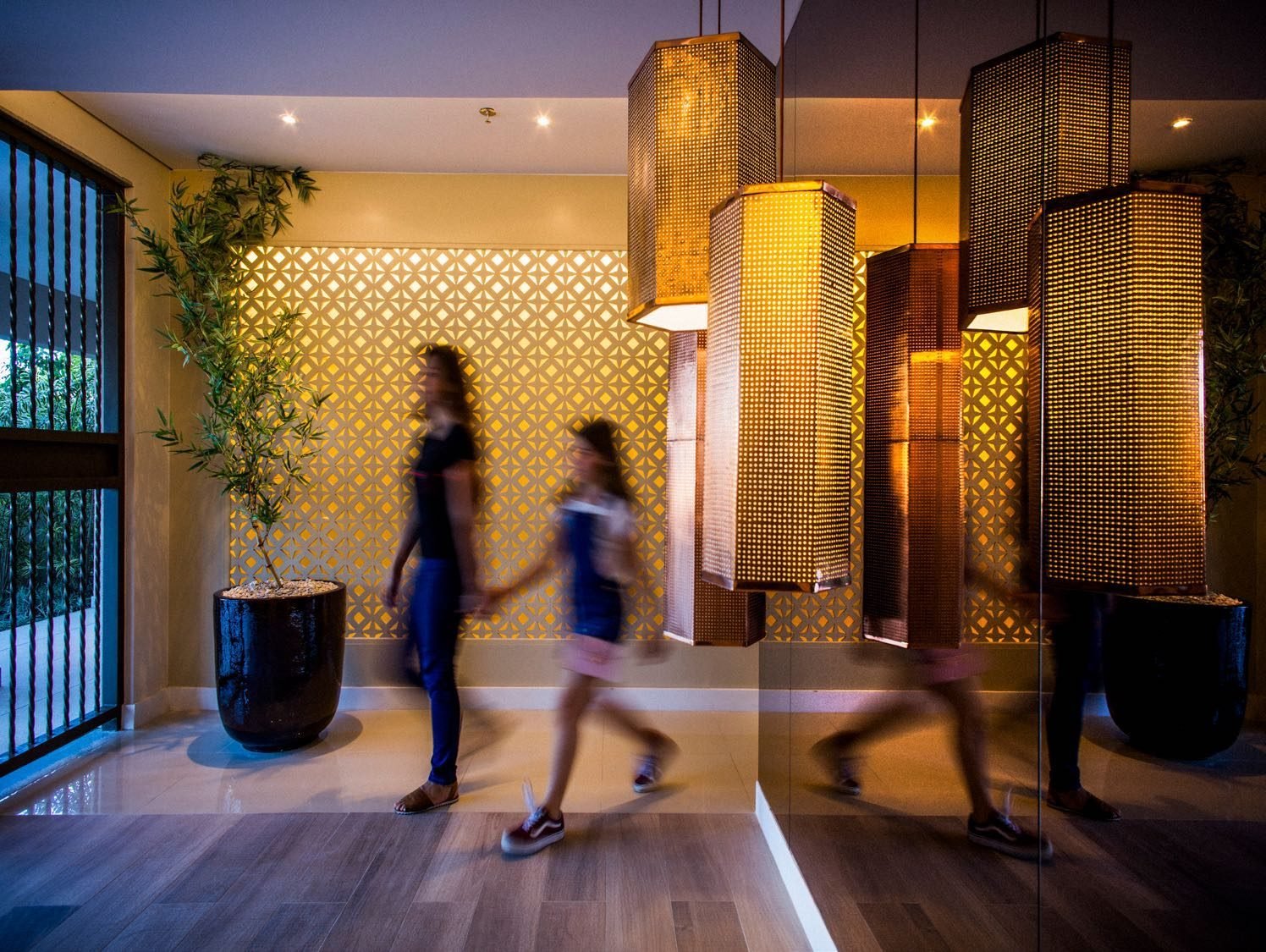 Lobby do Like Residencial Club, com pé-direito alto e luminárias em fibra