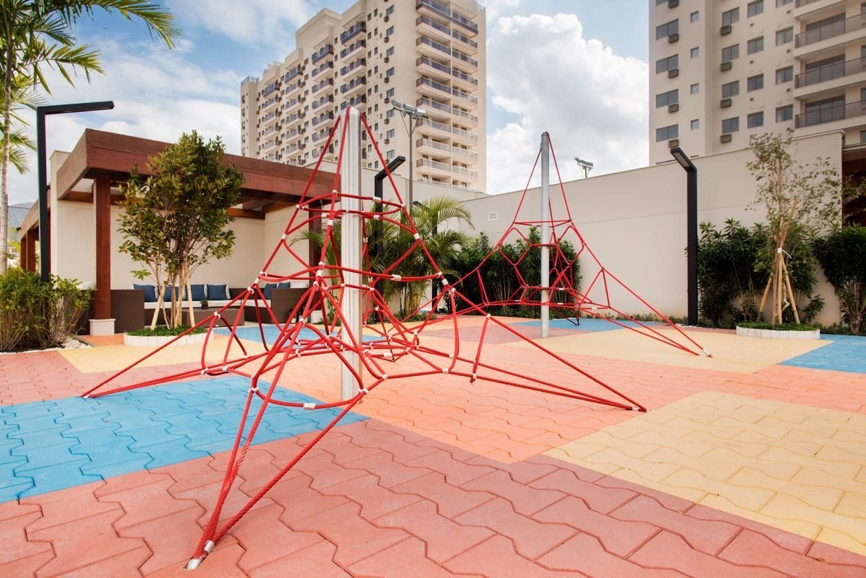 Playground aventura do Like Residencial Club, com trepa-trepa vermelho e piso emborrachado