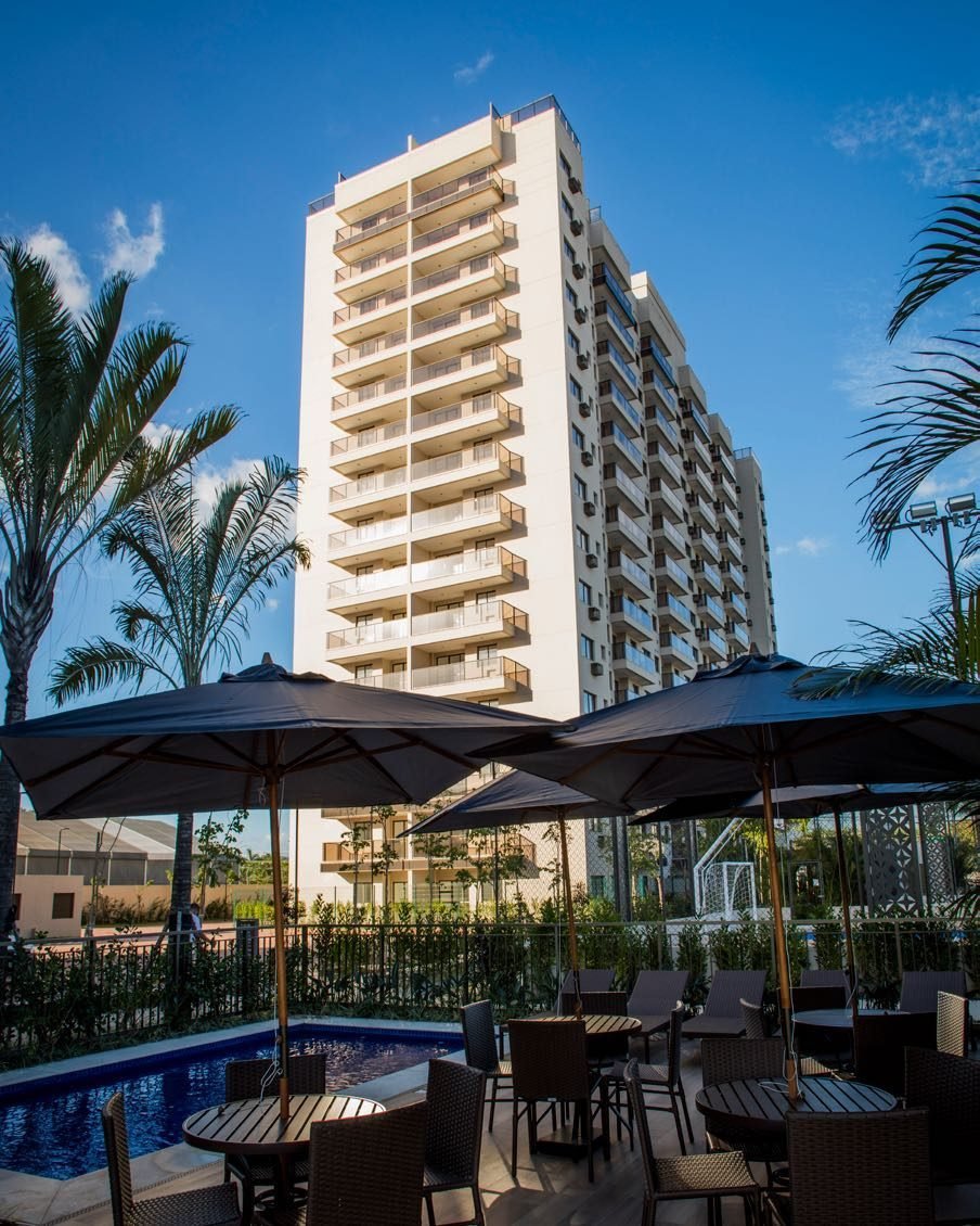 Gazebos junto à piscina do Like Residencial Club, com ombrelones e espreguiçadeiras