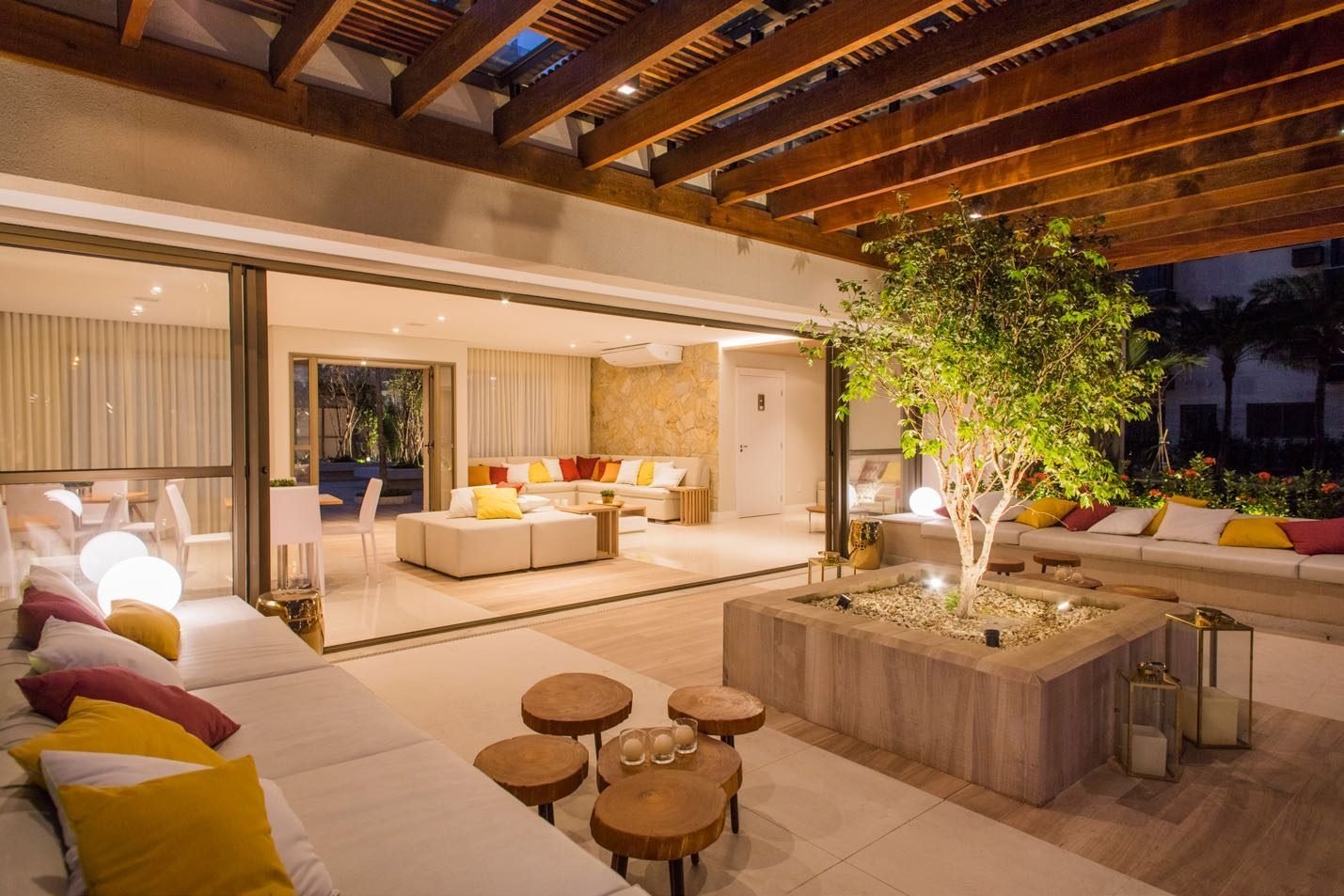 Varanda do salão de festas do Like Residencial Club, com pergolado de madeira e jardim