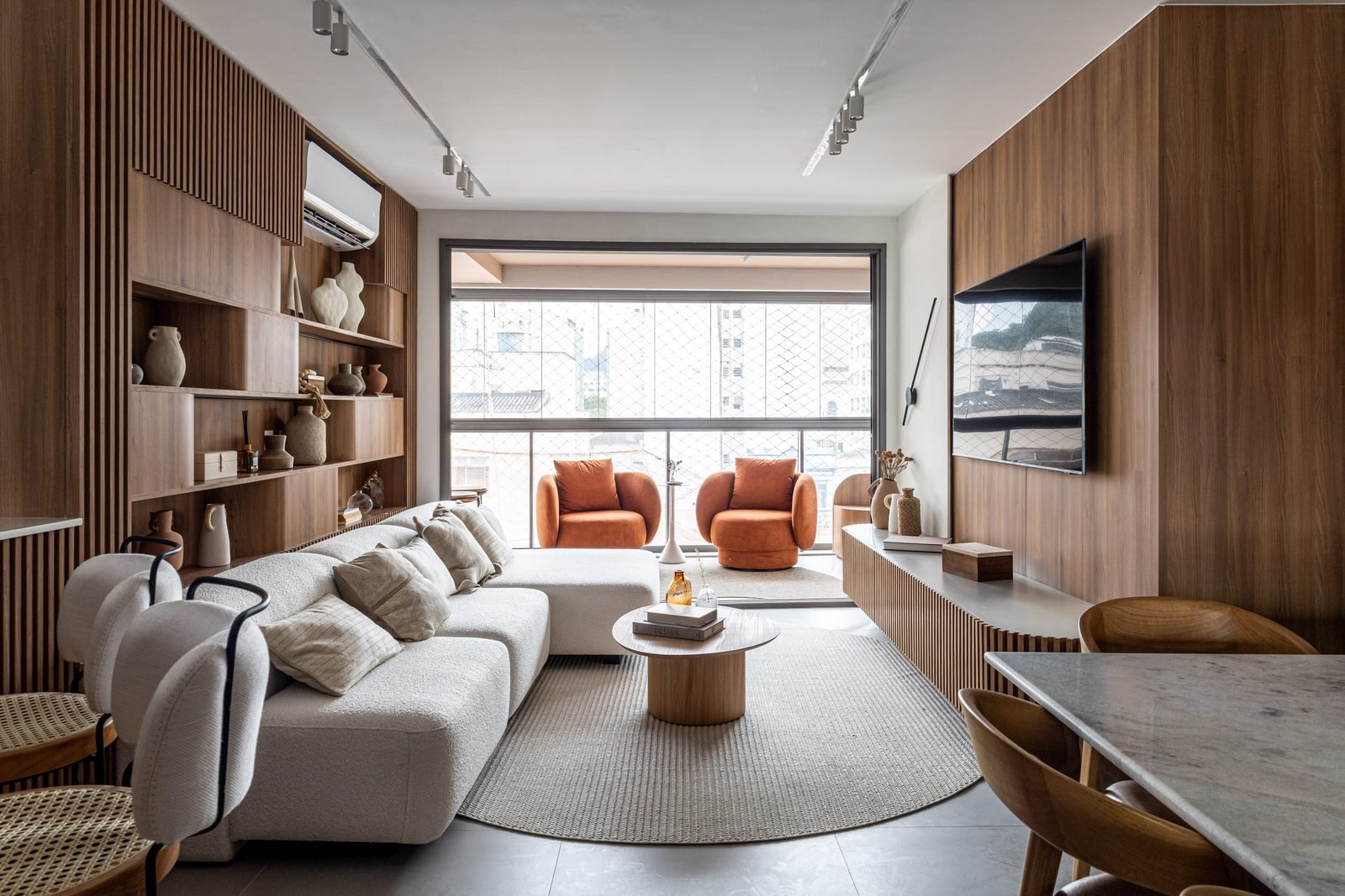 Living do decorado do Zenture, com marcenaria em madeira e painel de TV
