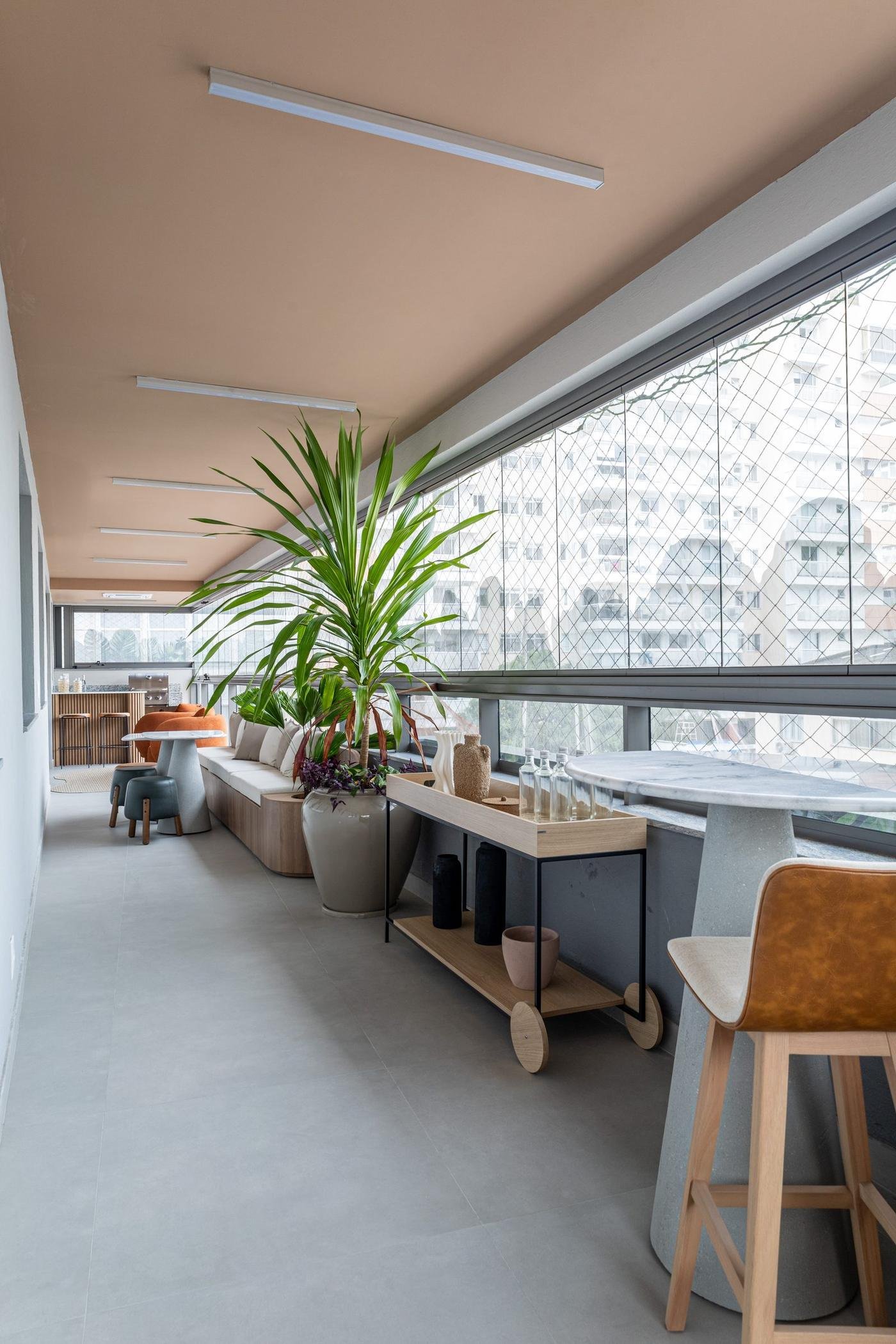 Varanda gourmet do decorado do Zenture, com mesa e vegetação