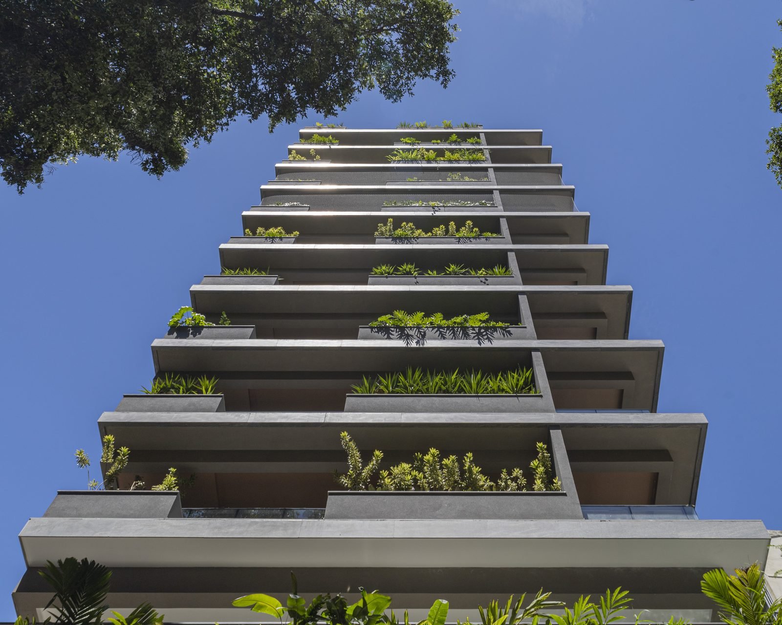 Fachada do Zenture Residencial em Botafogo, com jardineiras verdes em todas as varandas