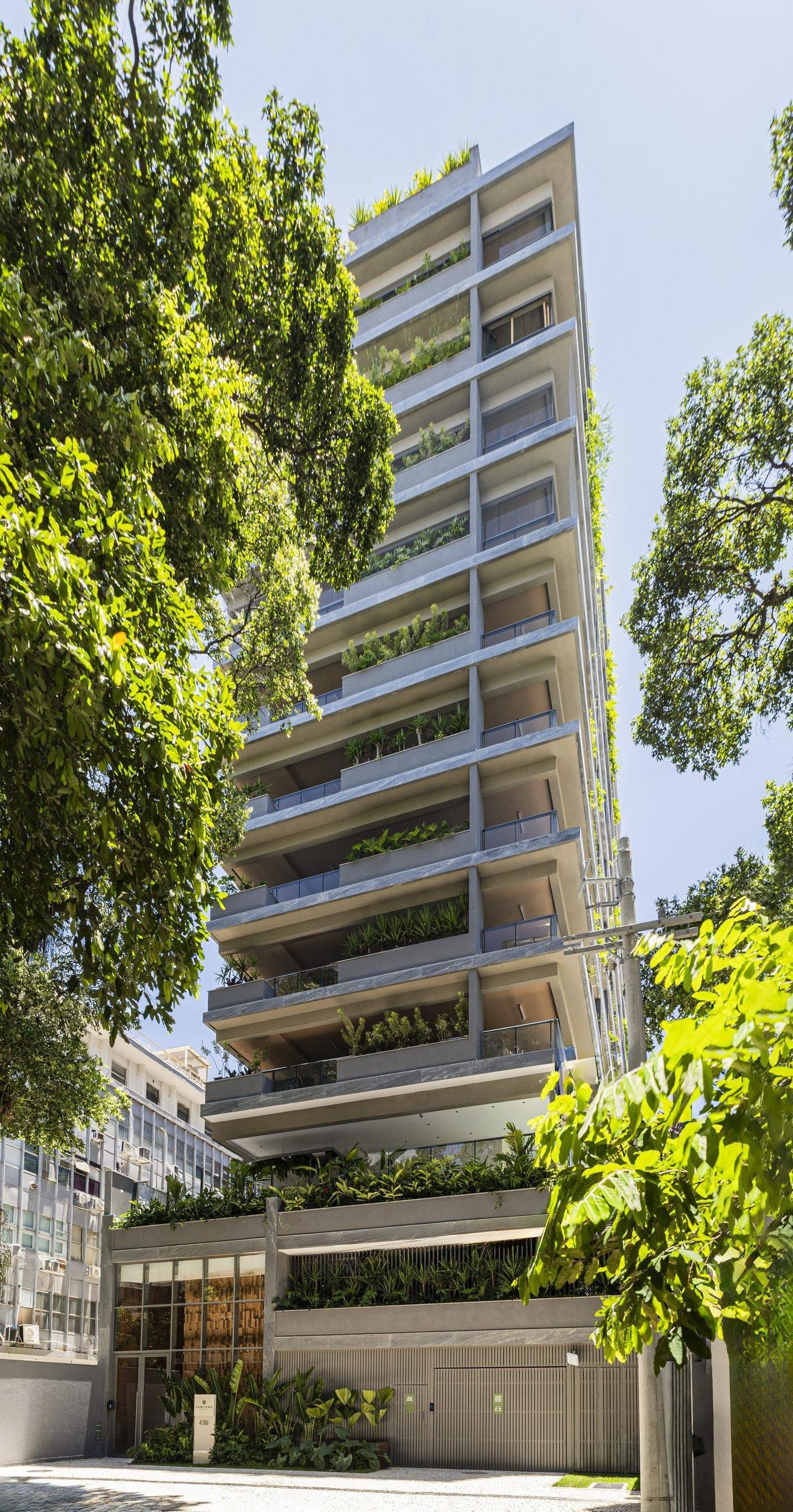 O Zenture visto da rua, com a árvore em primeiro plano e as jardineiras em todos os pavimentos